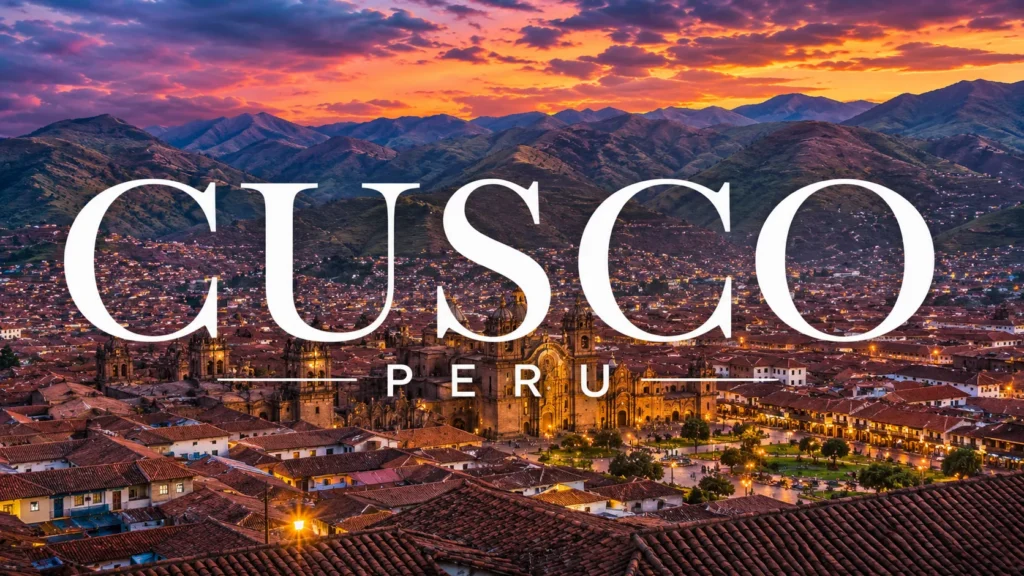 Cusco, Peru at sunset with historic cathedral, red-tiled rooftops, glowing city lights, and Andes mountains.