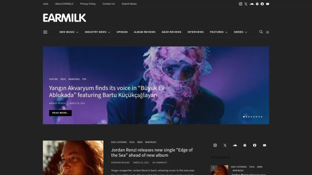 Earmilk music blog homepage with featured artist image, article headline, and new music releases section