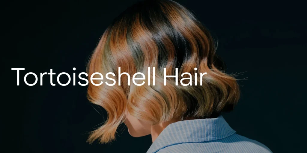 Short wavy bob hairstyle with tortoiseshell-inspired brown, caramel, and blonde highlights on a dark background.