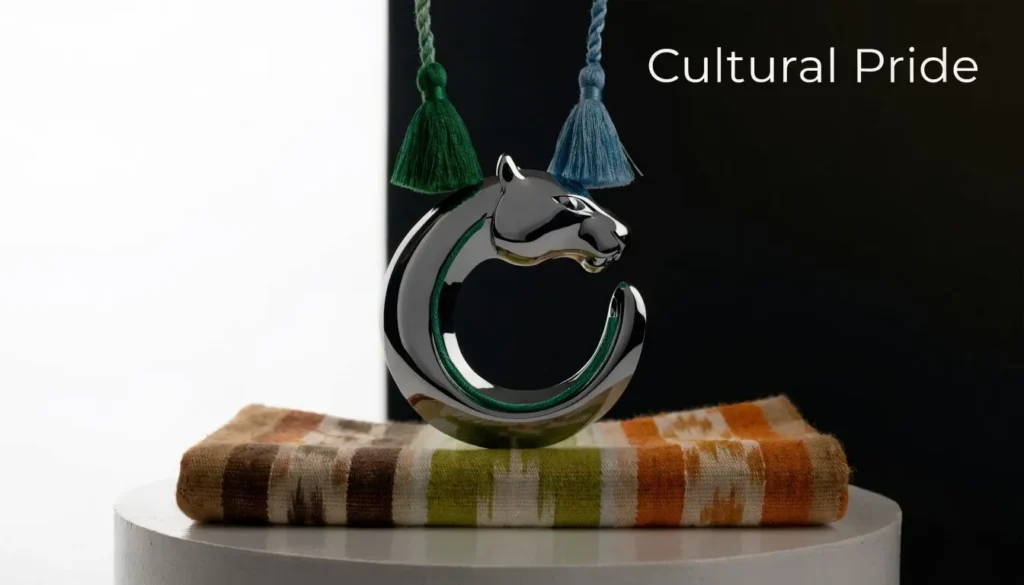 Panther-shaped metallic sculpture on patterned fabric beside tassels with “Cultural Pride” text.