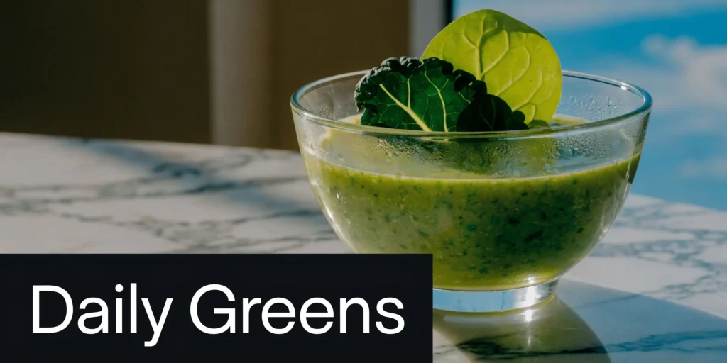 10 Cortisol Lowering Foods for Your 2026 Diet Plan Green smoothie topped with leafy greens in a glass bowl beside “Daily Greens” text on a marble table.