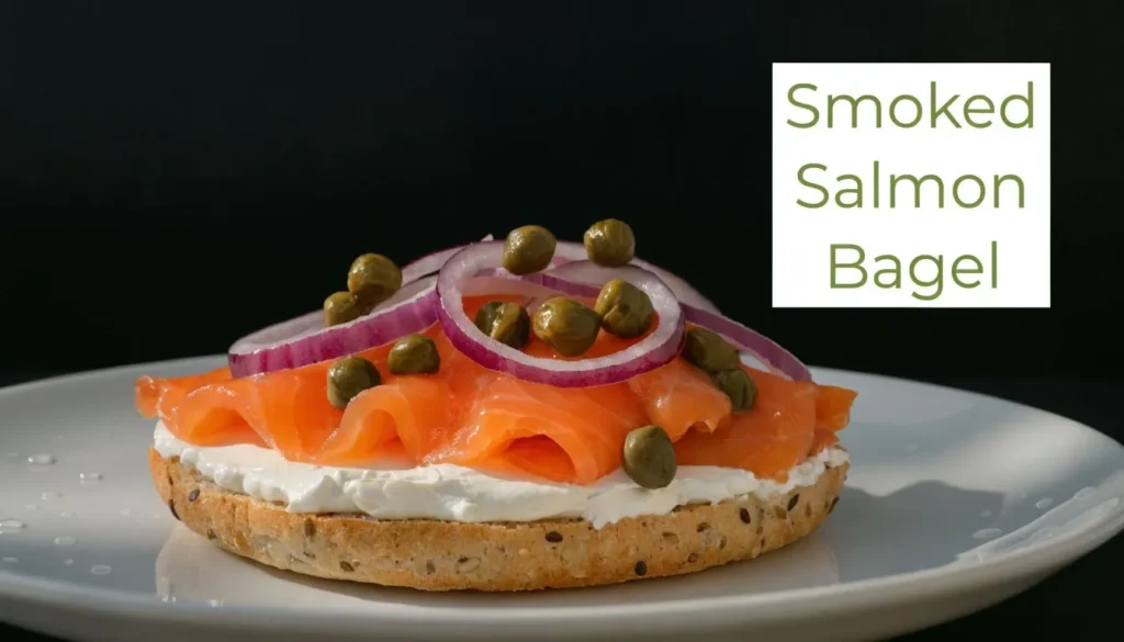 Smoked salmon bagel topped with cream cheese, red onion, and capers on a white plate.