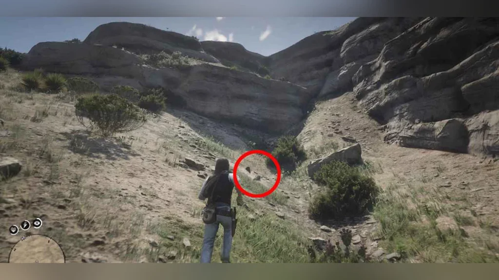 Red Dead Redemption 2 character exploring a rocky desert canyon with a dinosaur bone location marked in red.