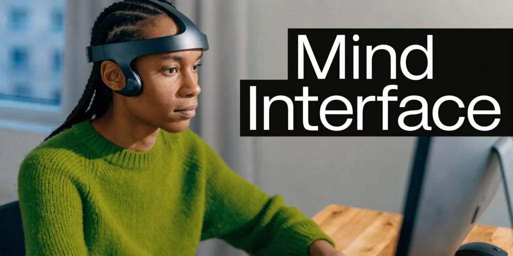 Person wearing a futuristic brain-computer headset beside “Mind Interface” text at a computer desk.